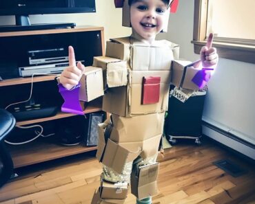 KIDS MOCK A POOR CLASSMATE FOR HIS CARDBOARD HALLOWEEN COSTUME UNTIL A MALE VOICE INTERRUPTS THEM “Look at Levi, he’s wearing a piece of colored cardboard!” a boy shouted, bursting into laughter. “He couldn’t even get a real costume!” “Don’t say that, Tony!” Levi’s voice trembled as tears welled up in his eyes. “My dad worked hard on this! He watched so many videos and put in so much effort!” “Oh yeah?”another kid chimed, smirking with his friends. “Well, that ‘costume’ makes you look like a loser! Bet your dad’s a loser too!” The other kids joined in, their cruel words hitting Levi like punches. He could feel the tears rolling down his cheeks. The laughter and mean comments were too much. Levi stood there, crying, wishing he could just disappear. And then, all of a sudden, the room fell silent. There was a loud gasp from the crowd, and when Levi looked up, he couldn’t believe what he saw on the stage.